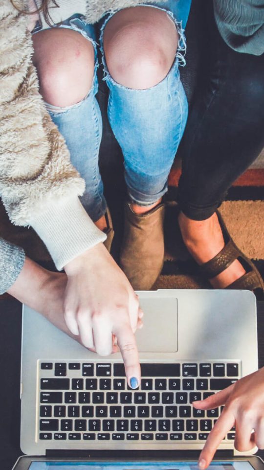 people gathered around a laptop