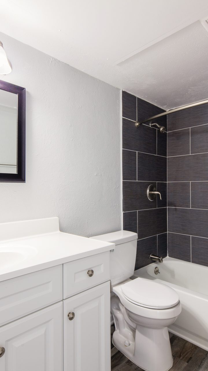bathroom white vanity grey tile tub surround