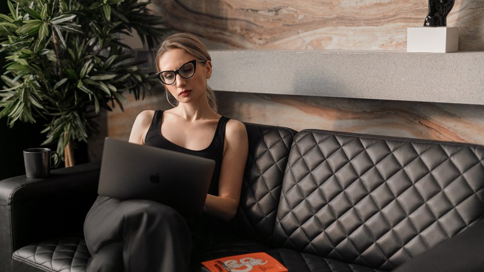 woman in black tank top wearing sunglasses sitting on black leather couch